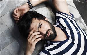 Pakistani & Bollywood actor, Fawad Khan in a contemplative mood wearing a Gant blue striped t-shirt